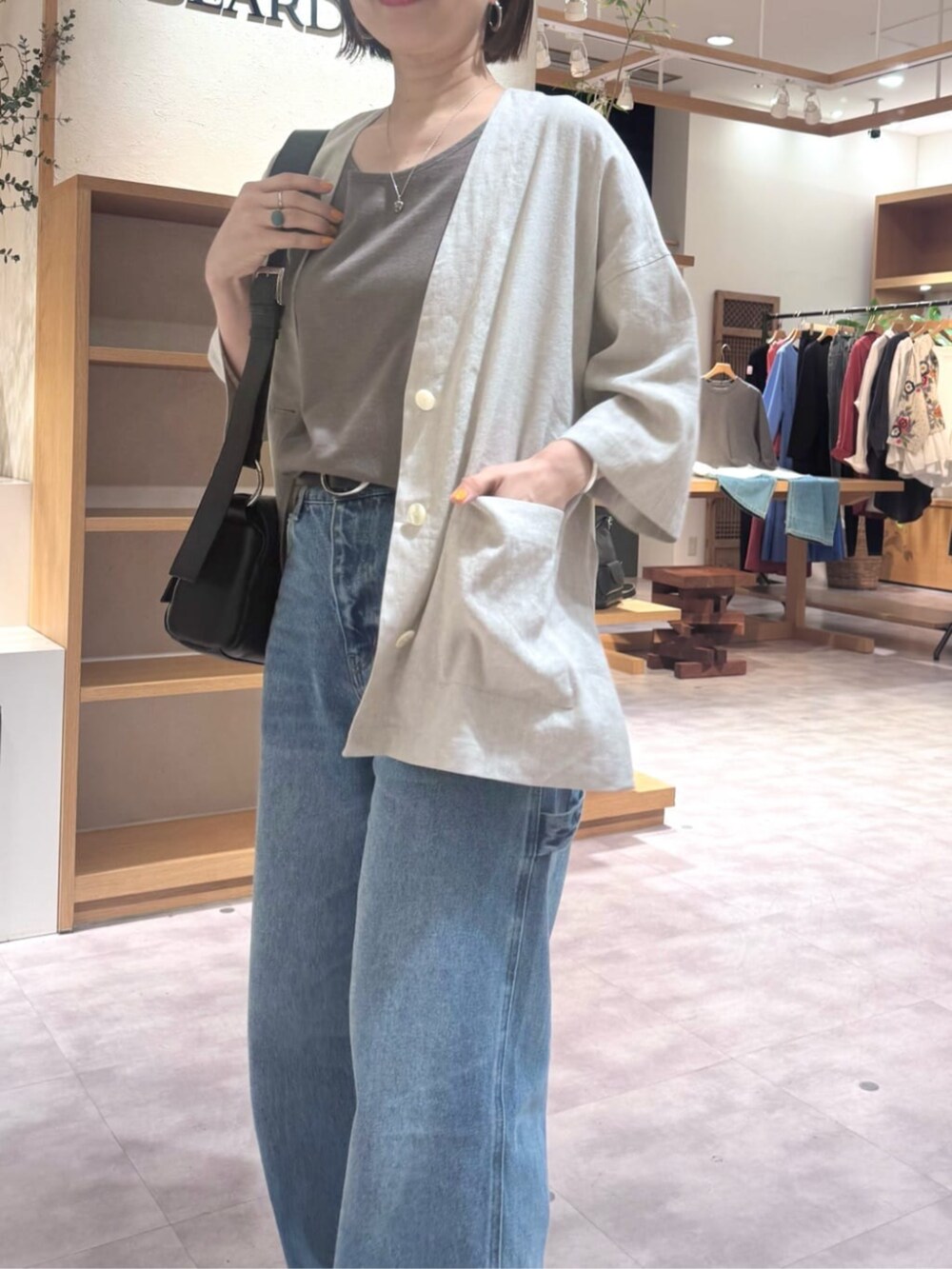 ブラック系のショルダーバッグ、ブルー系のその他パンツ、ブラウン系のキャミソールを着用したレディースの春コーディネートの6枚目の写真