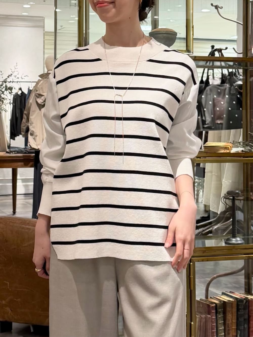 ブラック系のボストンバッグ、ホワイト系のニット/セーター、グレー系のその他パンツを着用したレディースの冬コーディネートの4枚目の写真