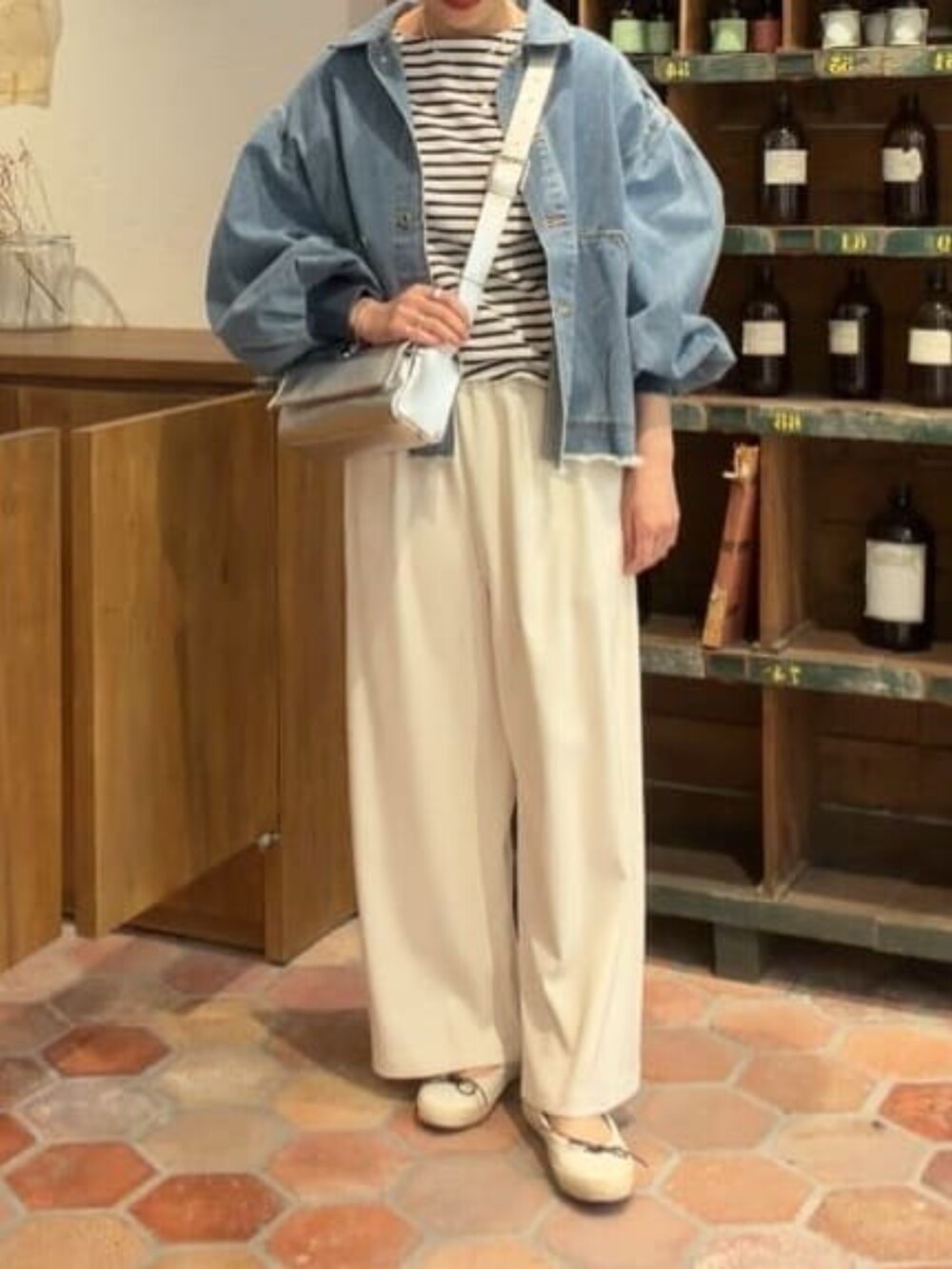 ブルー系のデニムジャケット、シルバー系のショルダーバッグ、ブルー系のTシャツ/カットソーを着用したレディースの冬コーディネートの4枚目の写真