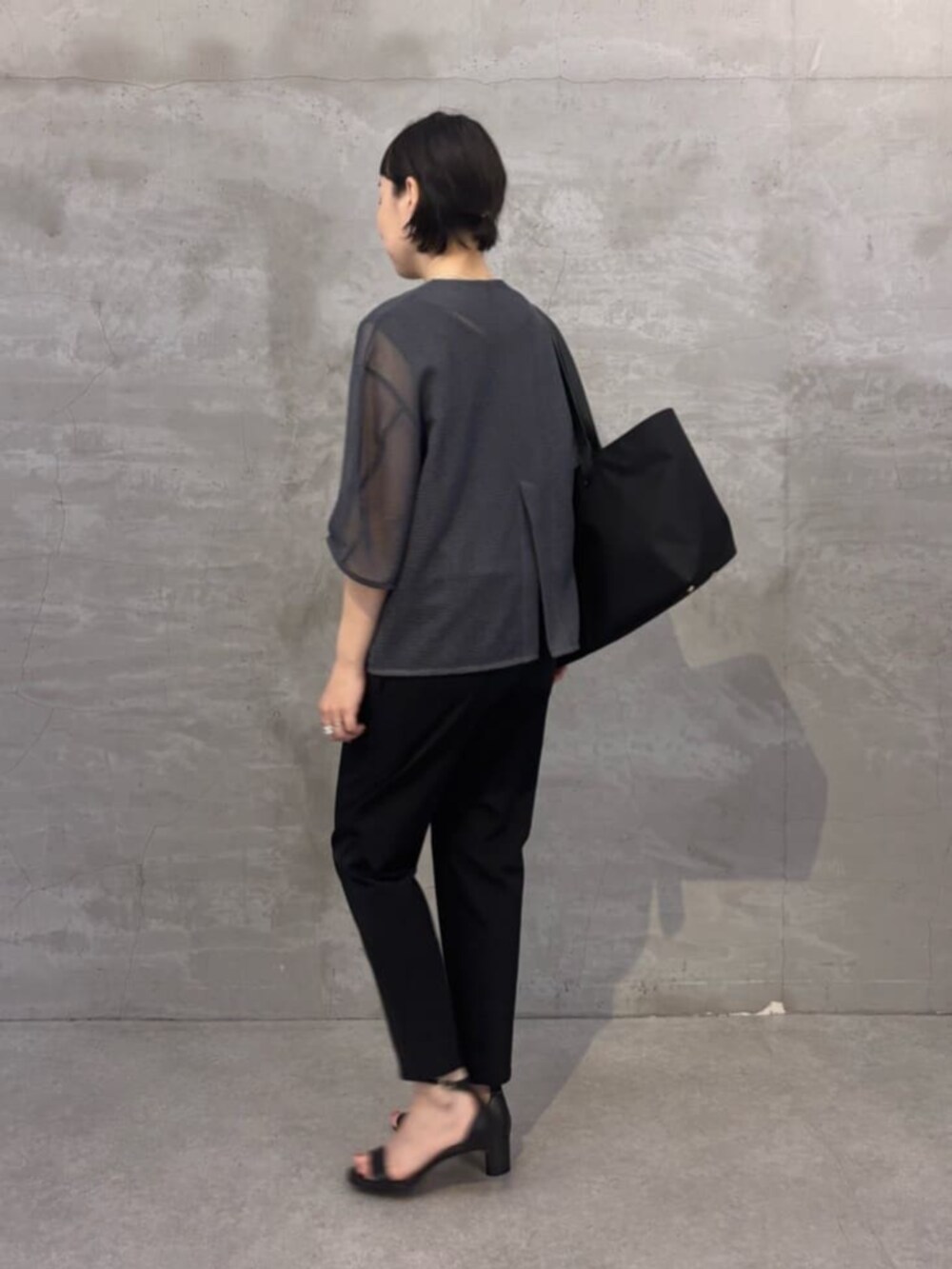 ブラック系のその他パンツ、グレー系のシャツ/ブラウス、ブラック系のトートバッグを着用したレディースの春コーディネートの2枚目の写真