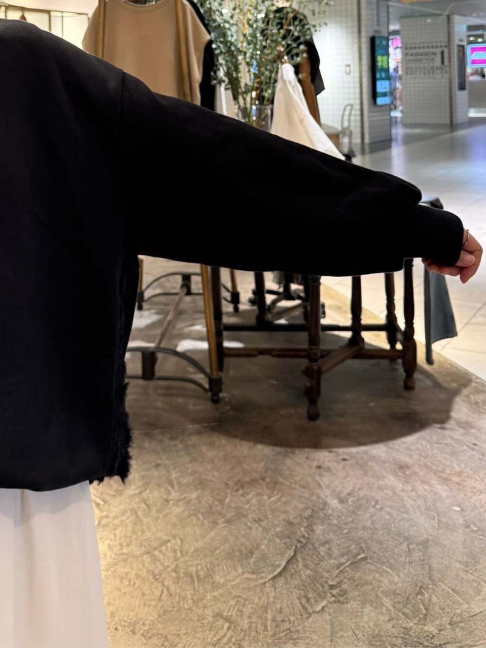 ブラック系のトートバッグ、ベージュ系のスカート、ブラック系のTシャツ/カットソーを着用したレディースの秋コーディネートの7枚目の写真