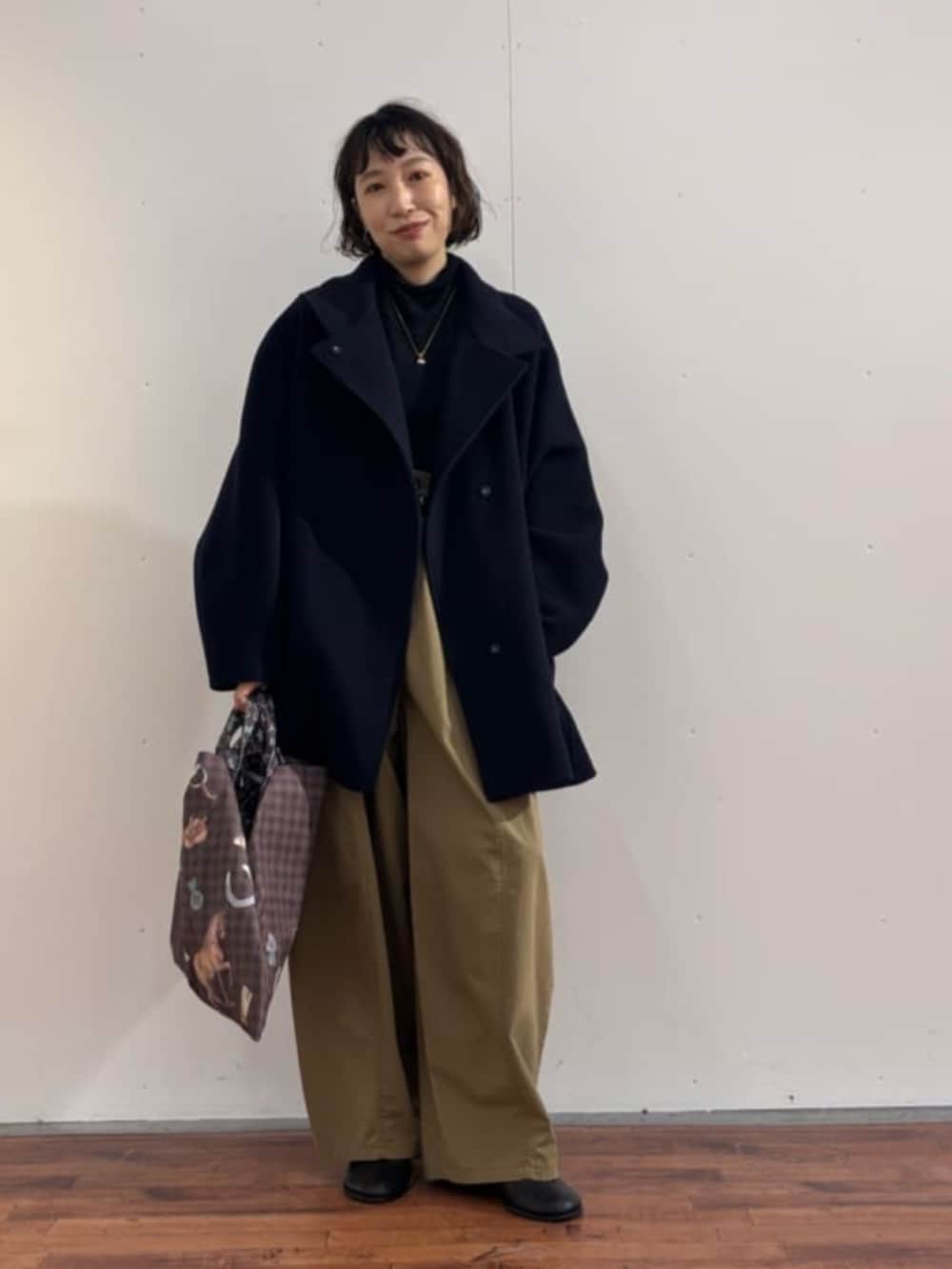 イエロー系のその他パンツ、ブラック系のニット/セーター、ブラック系のブーツを着用したレディースの秋コーディネートの2枚目の写真