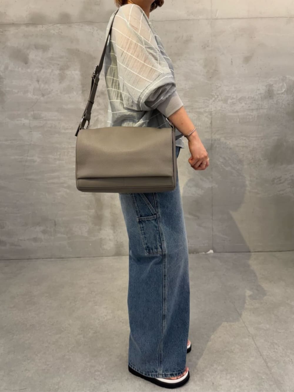 ブルー系のその他パンツ、ホワイト系のサンダル、グレー系のシャツ/ブラウスを着用したレディースの春コーディネートの2枚目の写真