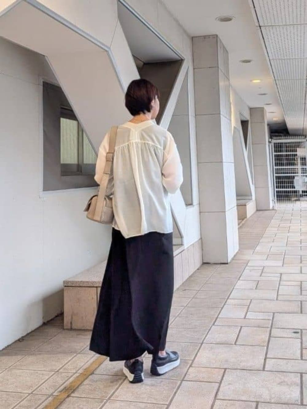 ホワイト系のシャツ/ブラウス、ブラック系のワンピース、ブラック系のスニーカーを着用したレディースの夏コーディネートの4枚目の写真