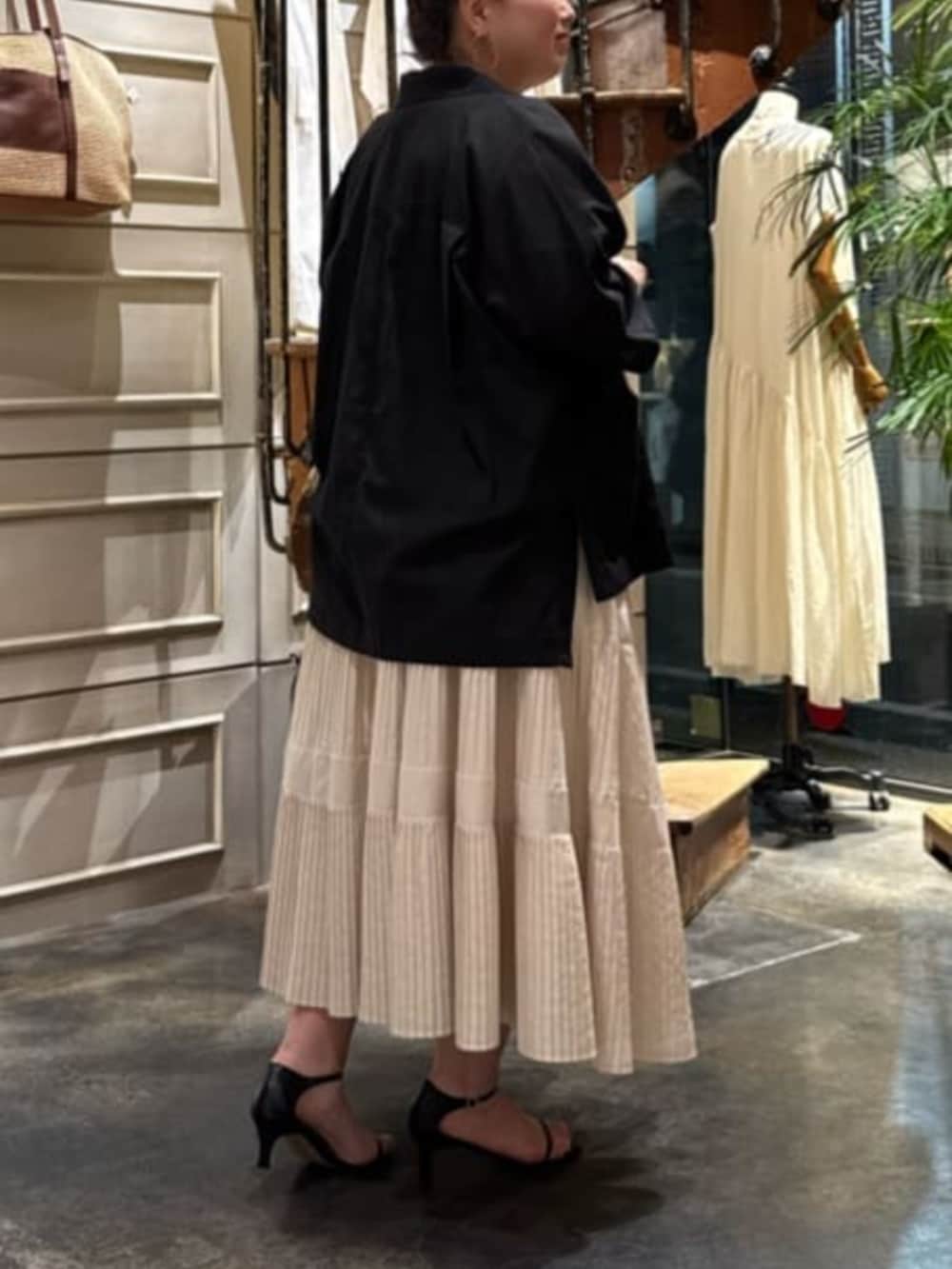 ホワイト系のスカート、ブラック系のテーラードジャケットを着用したレディースの春コーディネートの5枚目の写真