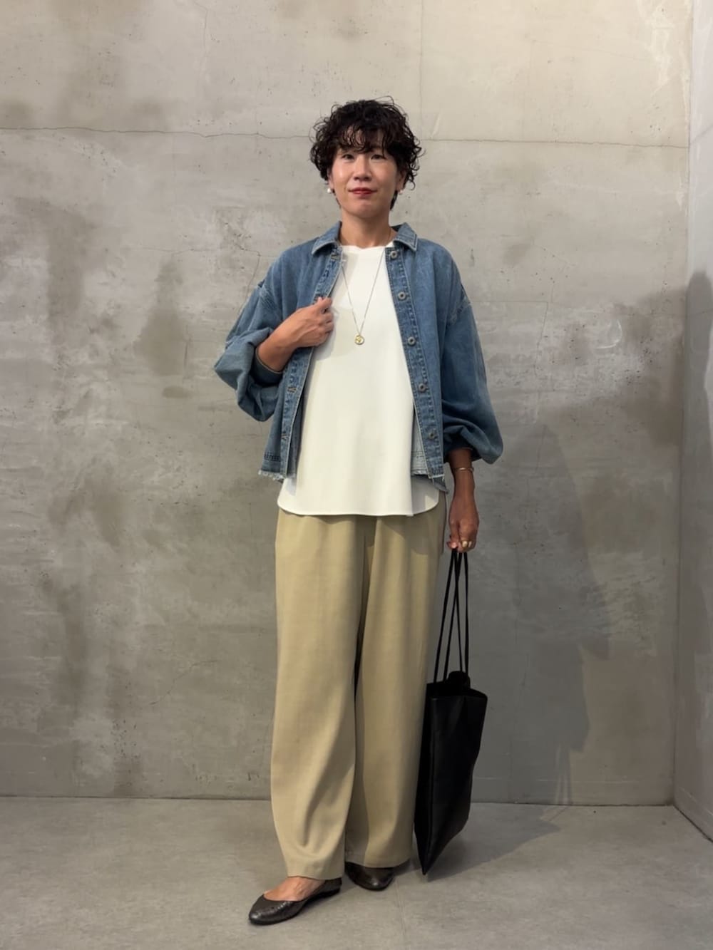ブルー系のデニムジャケット、ベージュ系のその他パンツ、ホワイト系のシャツ/ブラウスを着用したレディースの冬コーディネートの3枚目の写真