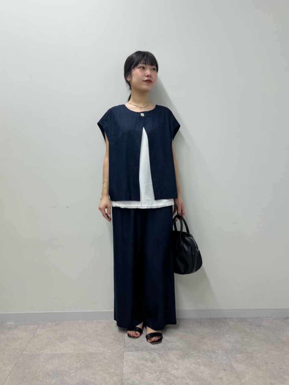 ブルー系のシャツ/ブラウス、ブルー系のその他パンツ、ブラック系のボストンバッグを着用したレディースの春コーディネートの5枚目の写真