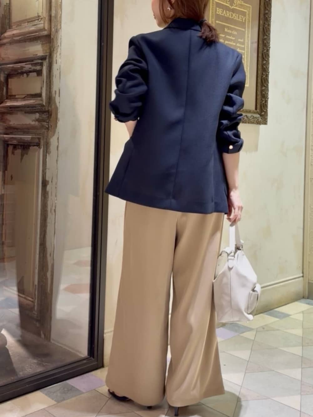 ブルー系のテーラードジャケット、ホワイト系のキャミソール、イエロー系のその他パンツを着用したレディースの春コーディネートの5枚目の写真