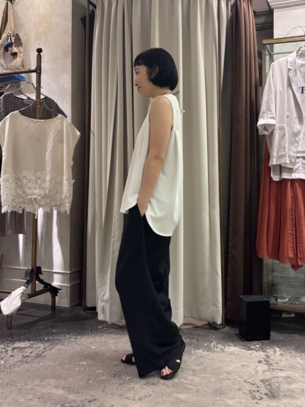 ブラック系のその他パンツ、ホワイト系のキャミソールを着用したレディースの夏コーディネートの2枚目の写真