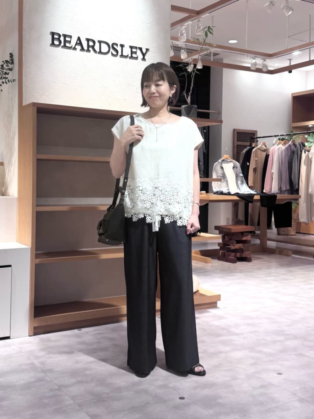 ブルー系のその他パンツ、ブラック系のトートバッグ、ホワイト系のシャツ/ブラウスを着用したレディースの春コーディネートの2枚目の写真