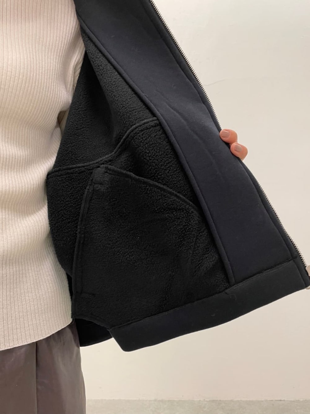 ブラック系のノーカラージャケット、ホワイト系のニット/セーター、ブラウン系のその他パンツを着用したレディースの冬コーディネートの5枚目の写真