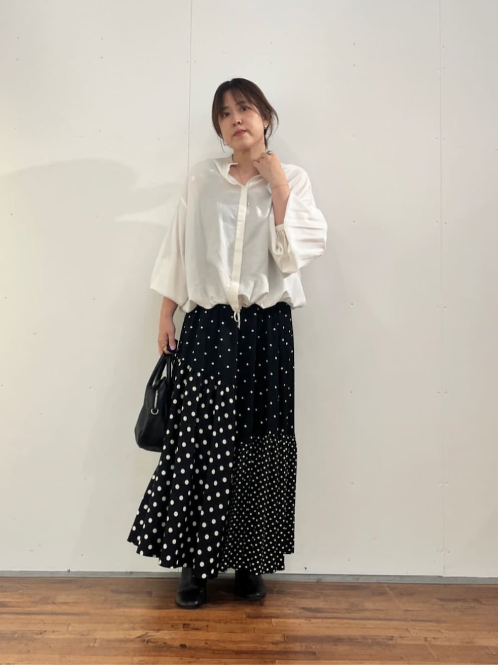 ブラック系のスカート、ホワイト系のシャツ/ブラウスを着用したレディースの夏コーディネートの2枚目の写真