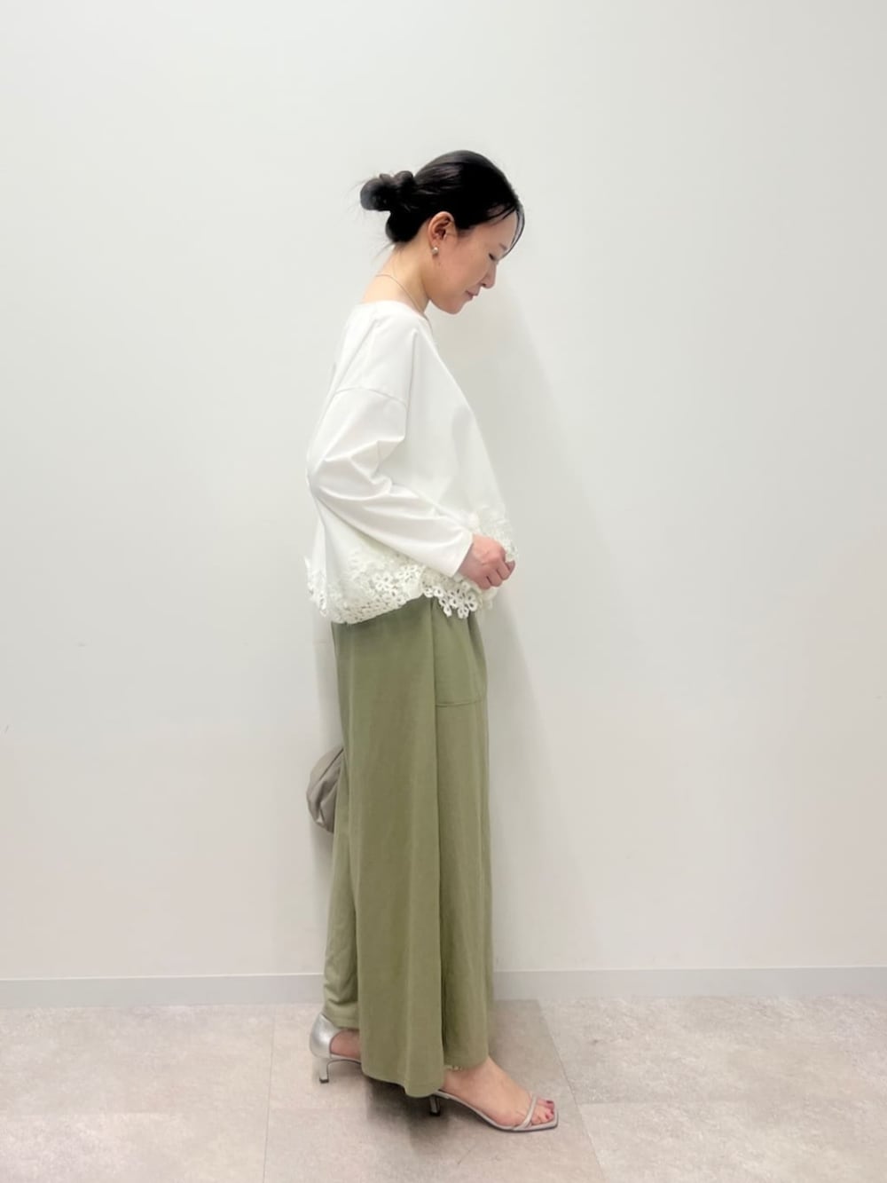 ベージュ系のショルダーバッグ、グリーン系のその他パンツ、ホワイト系のTシャツ/カットソーを着用したレディースの冬コーディネートの4枚目の写真