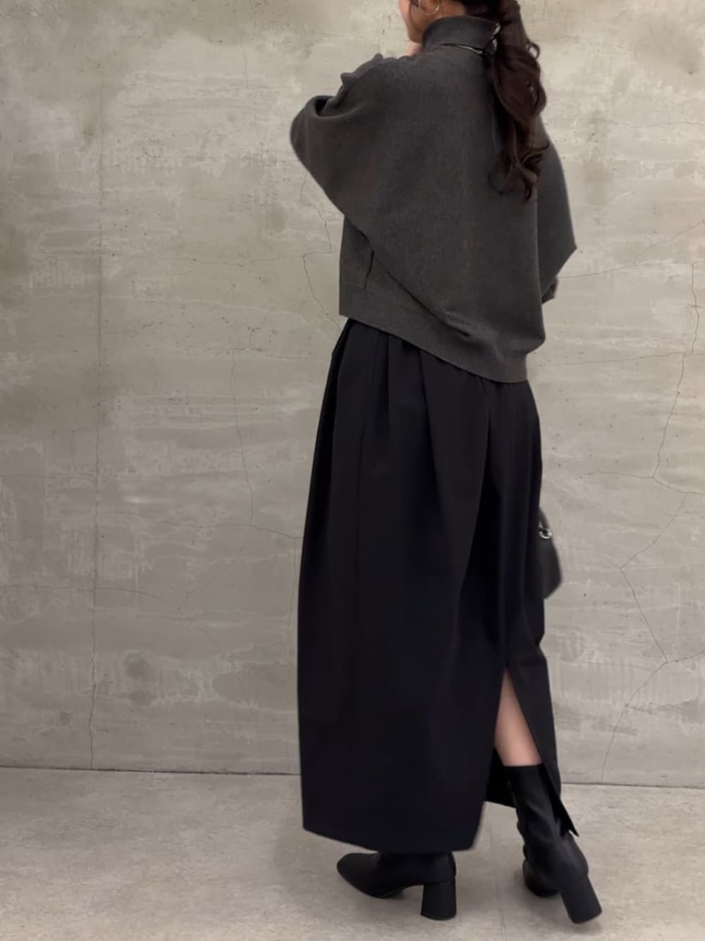 グレー系のニット/セーター、ブラック系のスカートを着用したレディースの冬コーディネートの5枚目の写真