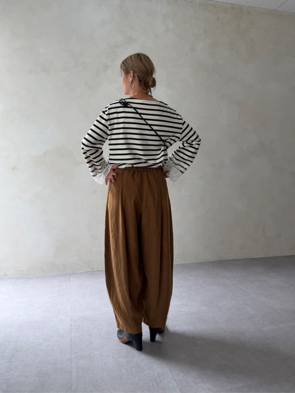 ホワイト系のTシャツ/カットソー、イエロー系のその他パンツ、ブラック系のポーチを着用したレディースの夏コーディネートの3枚目の写真