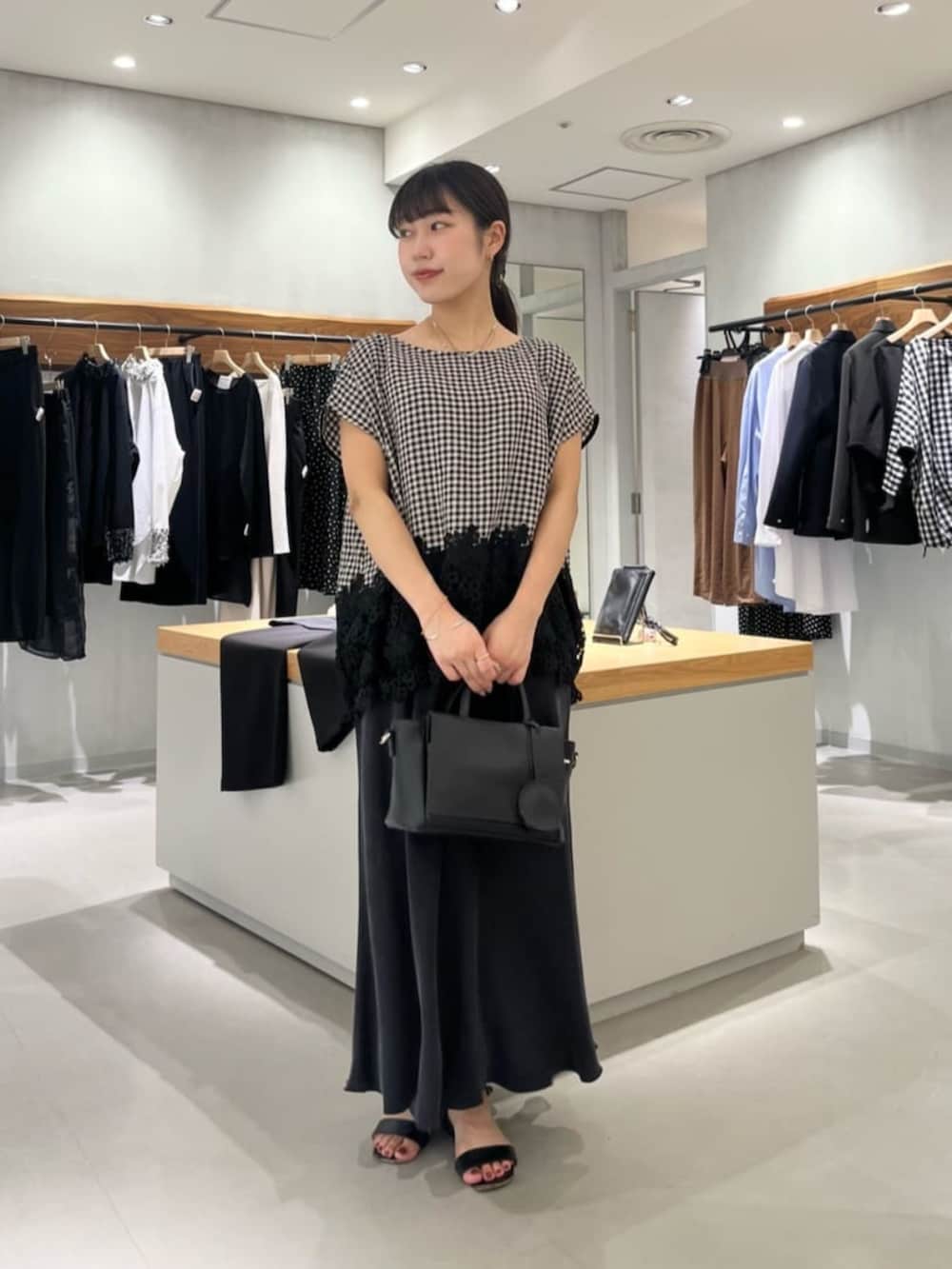 ブラック系のシャツ/ブラウスを着用したレディースの夏コーディネートの2枚目の写真