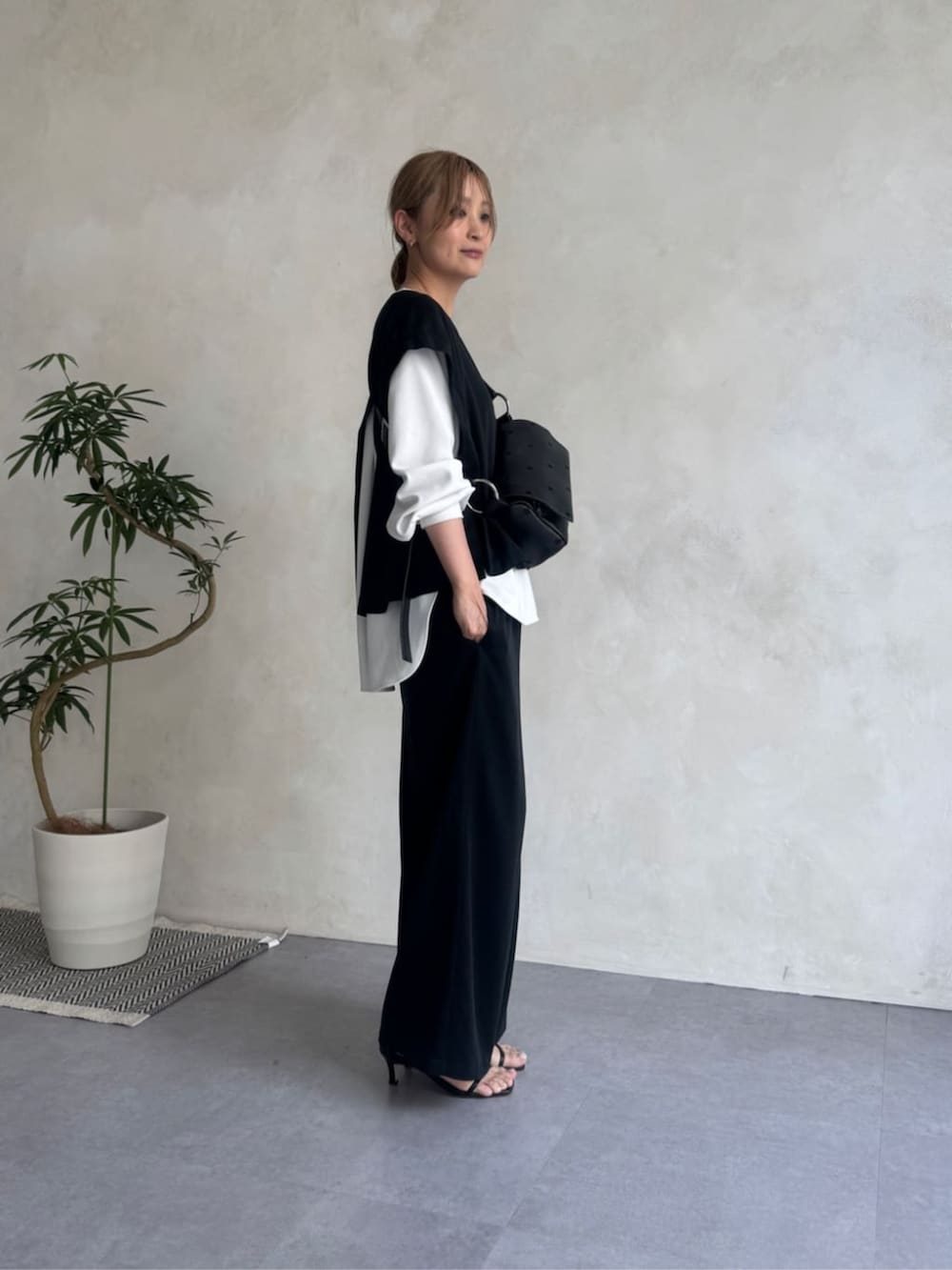 ブルー系のベスト、ブルー系のその他パンツ、ブラック系のショルダーバッグを着用したレディースの夏コーディネートの2枚目の写真