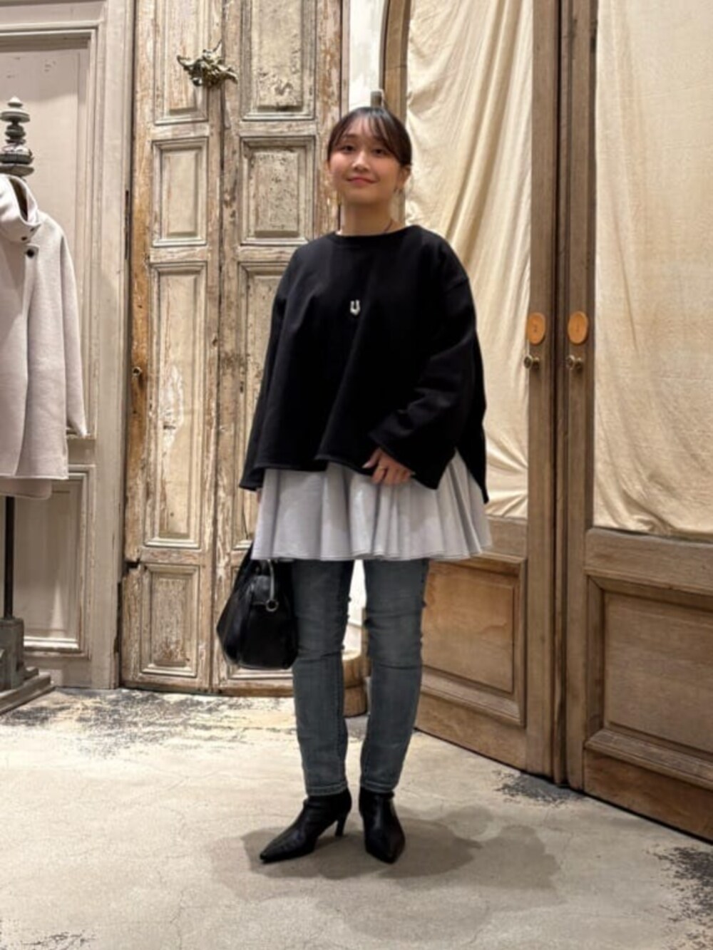 ブルー系のデニムパンツ、ブラック系のボストンバッグ、ブラック系のTシャツ/カットソーを着用したレディースの冬コーディネートの5枚目の写真