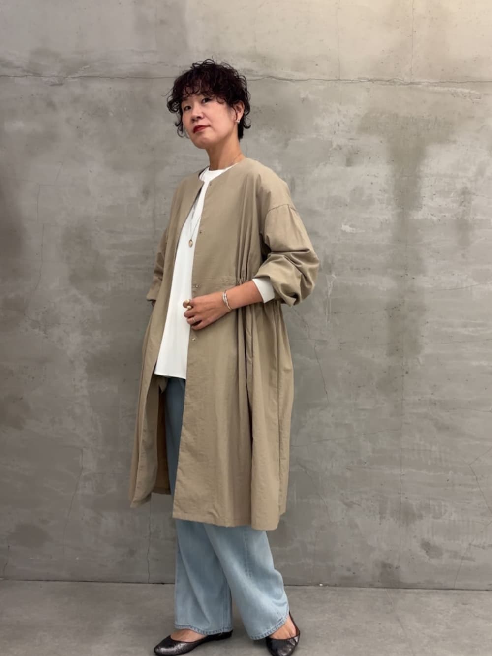 ベージュ系のその他アウター、ブラック系のボストンバッグ、ブルー系のデニムパンツを着用したレディースの冬コーディネートの2枚目の写真