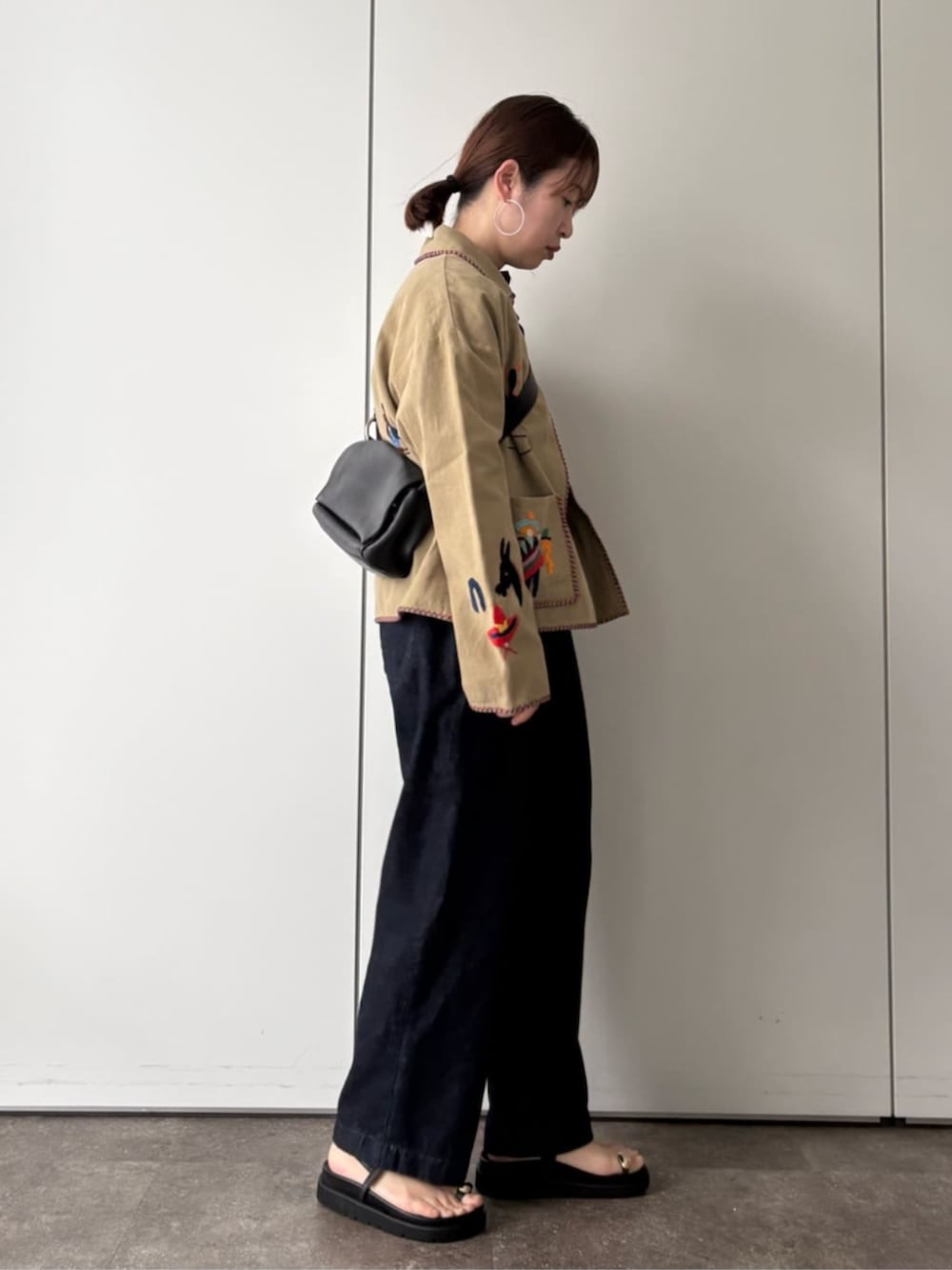 ベージュ系のその他アウター、ブラック系のショルダーバッグ、ブラック系のサンダルを着用したレディースの冬コーディネートの2枚目の写真