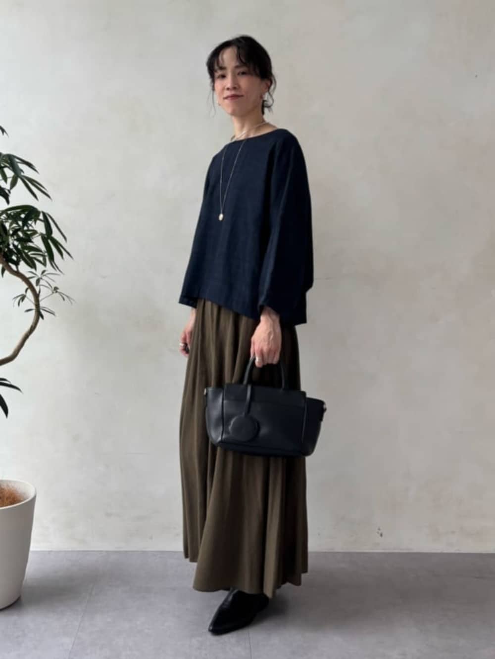 ブラック系のハンドバッグ、ブルー系のシャツ/ブラウス、グリーン系のその他パンツを着用したレディースの夏コーディネートの3枚目の写真