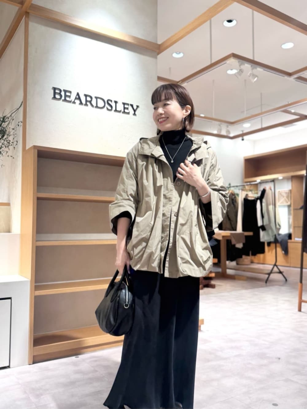 ブラック系のスカート、ブラウン系のブルゾンを着用したレディースの冬コーディネートの6枚目の写真