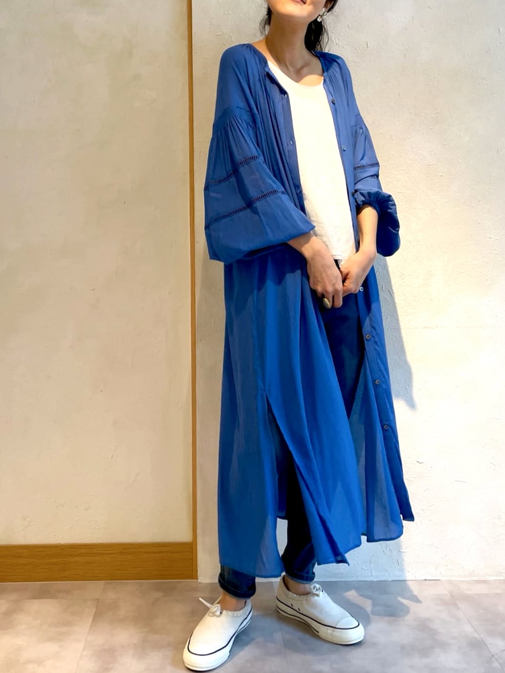 ブルー系のワンピース、ホワイト系のスニーカーを着用したレディースの春コーディネートの2枚目の写真