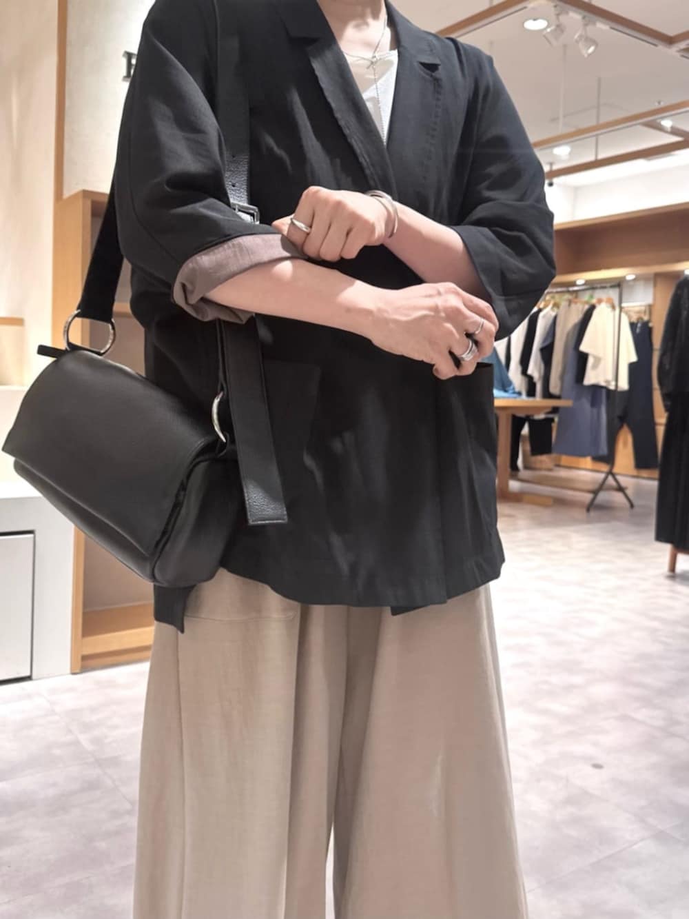 ブラック系のテーラードジャケット、ベージュ系のその他パンツ、ホワイト系のサンダルを着用したレディースの春コーディネートの10枚目の写真