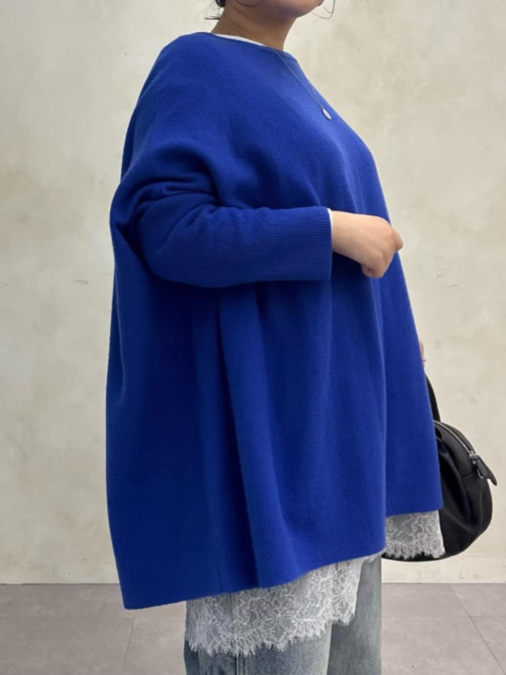 ブルー系のデニムパンツ、ブルー系のニット/セーター、ホワイト系のTシャツ/カットソーを着用したレディースの秋コーディネートの6枚目の写真