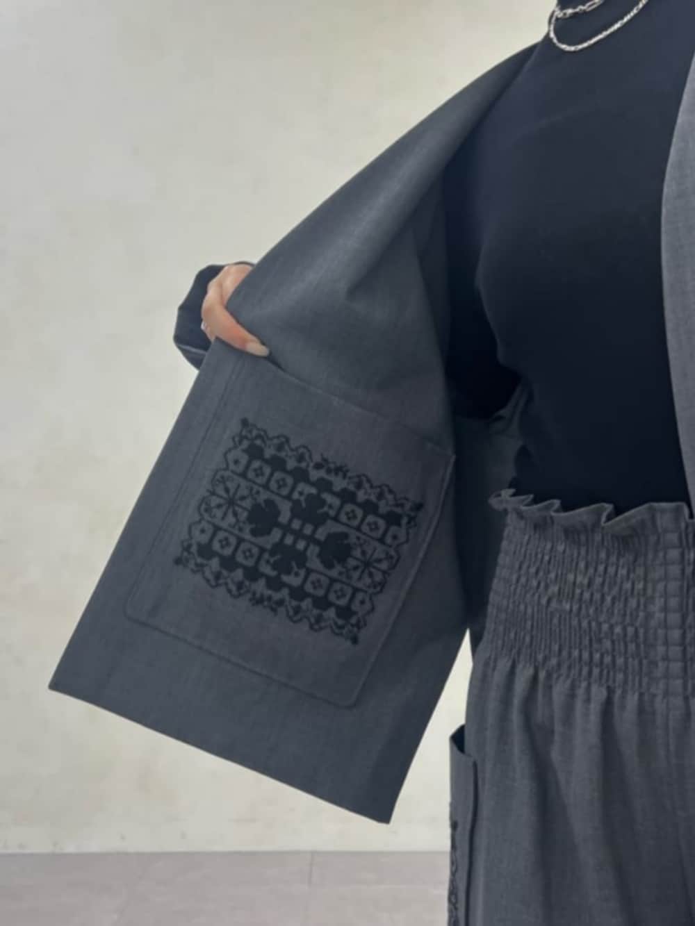 ブラック系のニット/セーター、グレー系のその他パンツ、グレー系のテーラードジャケットを着用したレディースの秋コーディネートの7枚目の写真