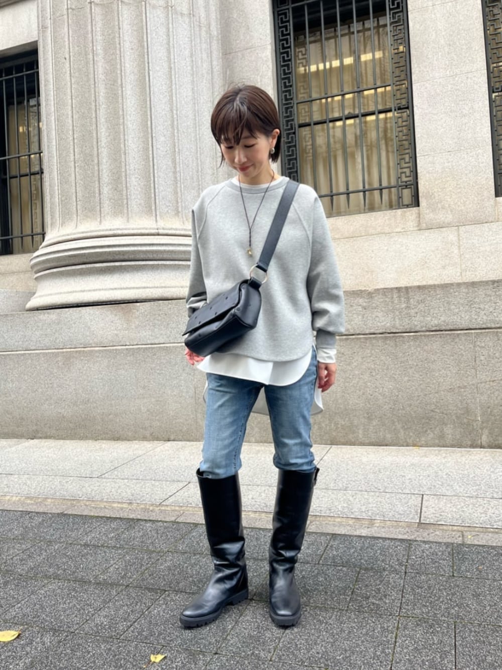 ホワイト系のシャツ/ブラウス、グレー系のTシャツ/カットソー、ブラック系のショルダーバッグを着用したレディースの冬コーディネートの2枚目の写真