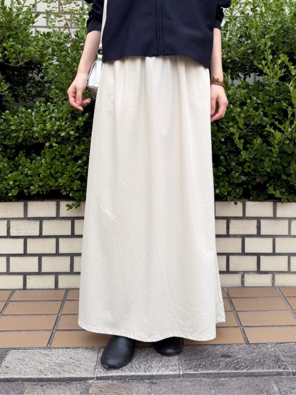 ベージュ系のスカート、ブルー系のカーディガン/ボレロ、シルバー系のトートバッグを着用したレディースの夏コーディネートの7枚目の写真