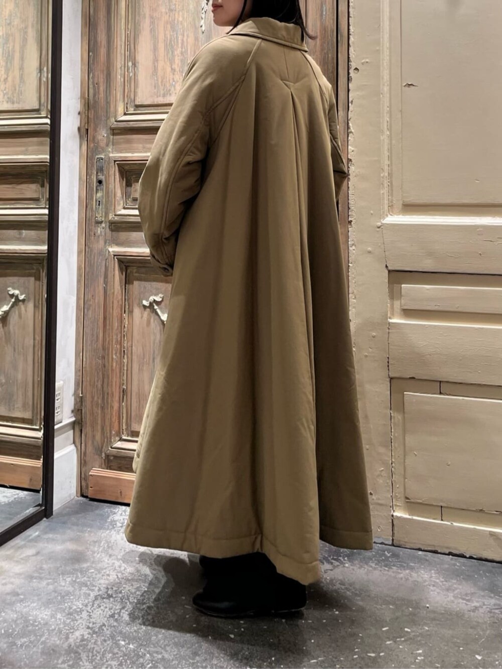 ブラック系のショルダーバッグ、イエロー系のその他アウター、ブラック系のチャームを着用したレディースの冬コーディネートの5枚目の写真