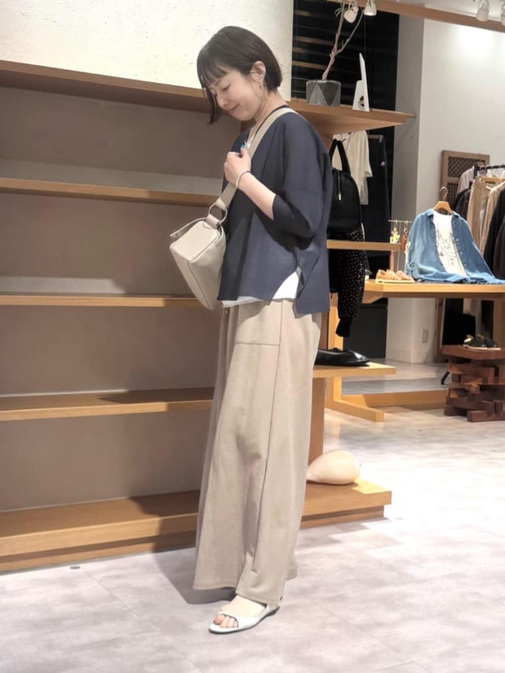 ベージュ系のその他パンツ、ベージュ系のショルダーバッグ、ブルー系のカーディガン/ボレロを着用したレディースの夏コーディネートの3枚目の写真