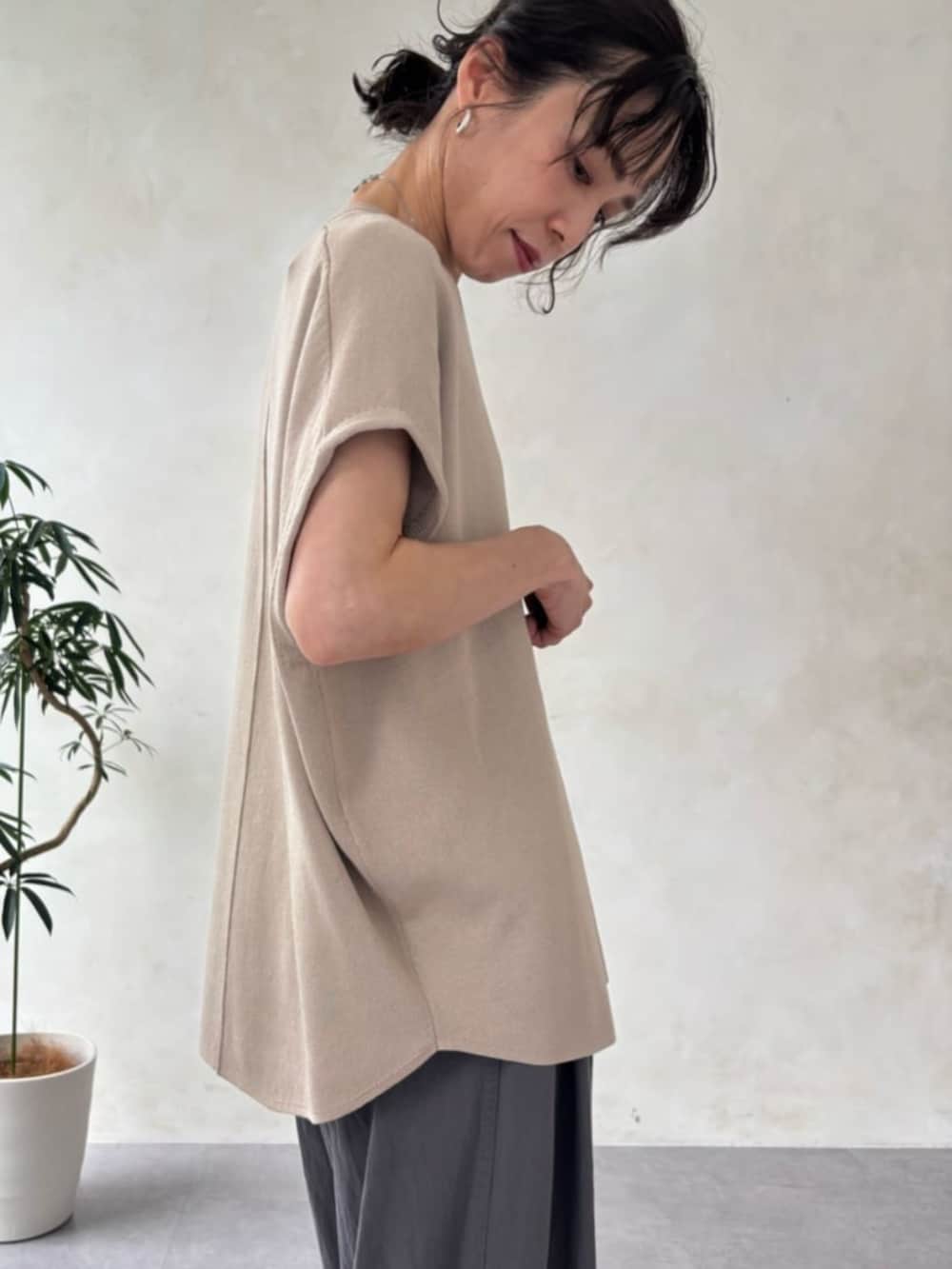 ベージュ系のニット/セーター、グレー系のその他パンツを着用したレディースの夏コーディネートの7枚目の写真