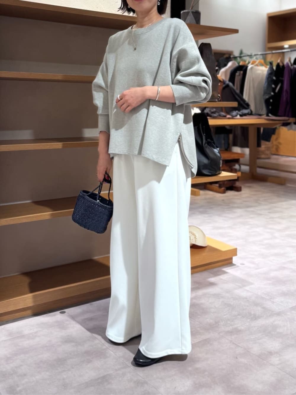 ホワイト系のその他パンツ、ブルー系のハンドバッグ、グレー系のニット/セーターを着用したレディースの冬コーディネートの5枚目の写真