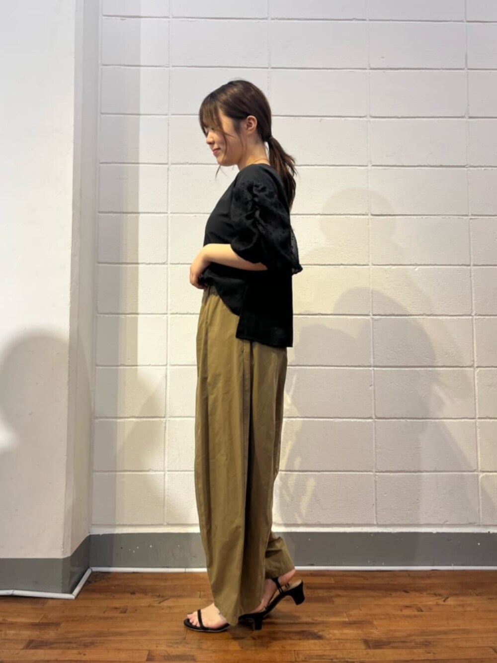 イエロー系のその他パンツ、ブラック系のシャツ/ブラウスを着用したレディースの夏コーディネートの2枚目の写真