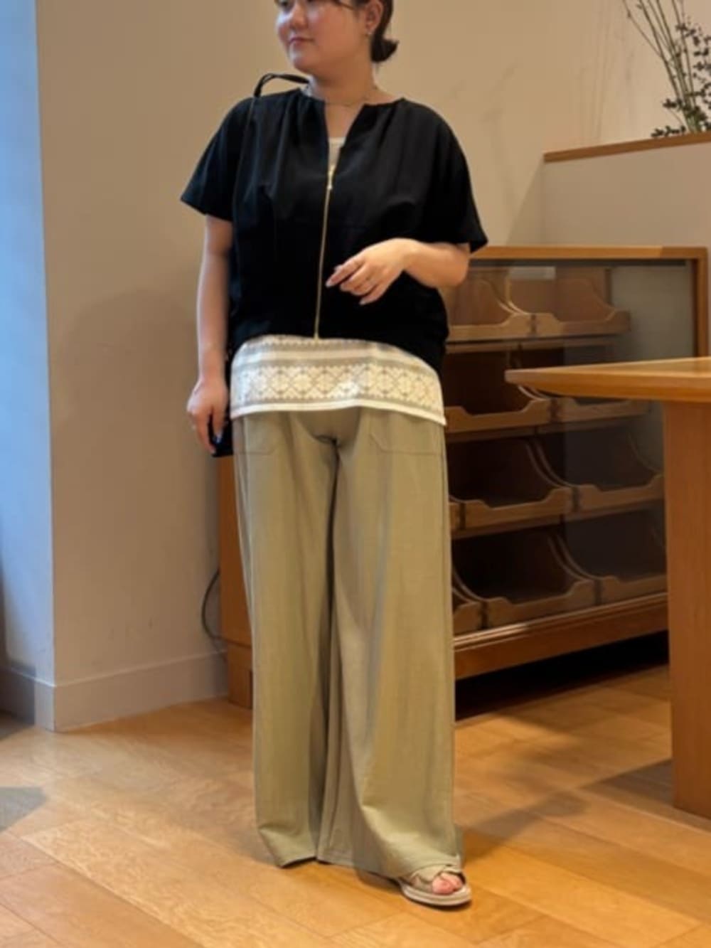 グリーン系のその他パンツ、ホワイト系のシャツ/ブラウス、ブラック系のベストを着用したレディースの春コーディネートの2枚目の写真