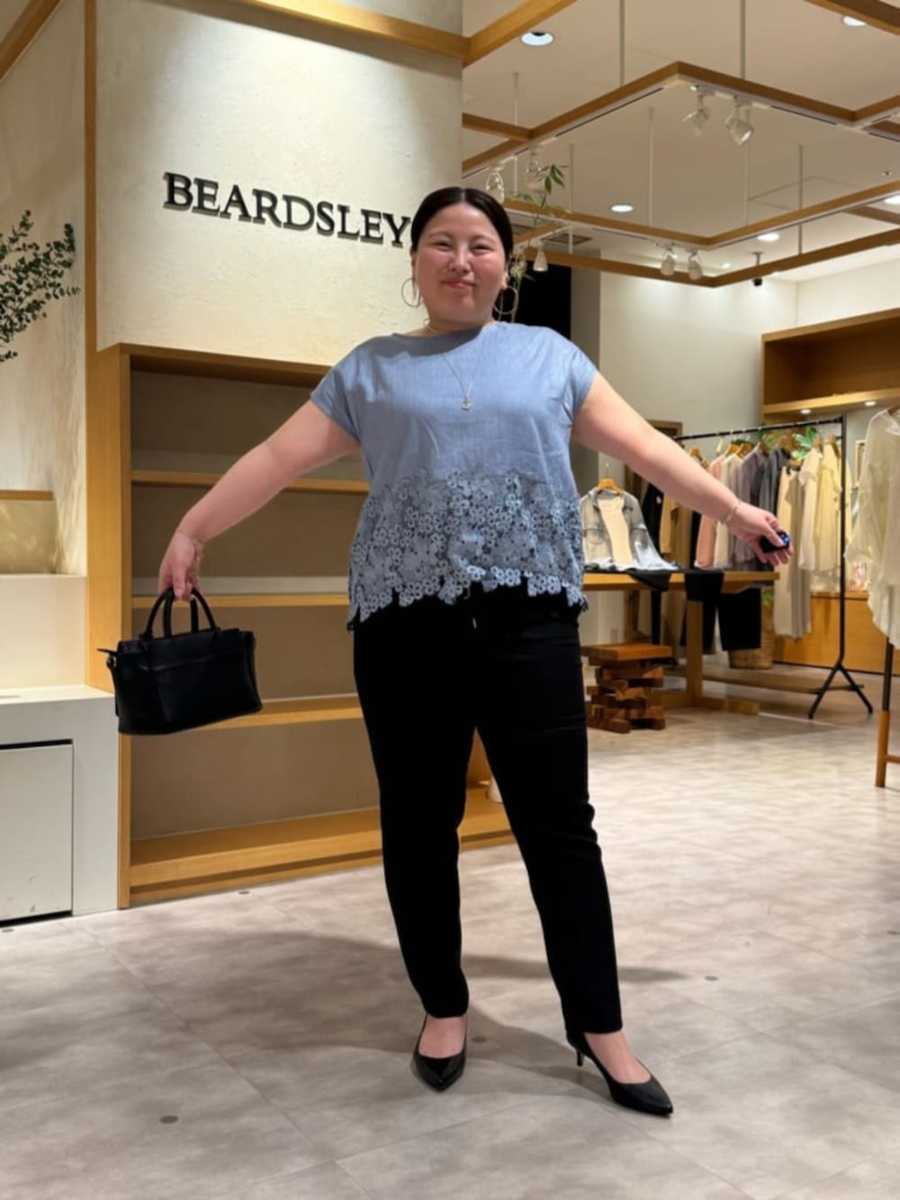 ブラック系のハンドバッグ、ブルー系のシャツ/ブラウス、ブラック系のその他パンツを着用したレディースの春コーディネートの5枚目の写真