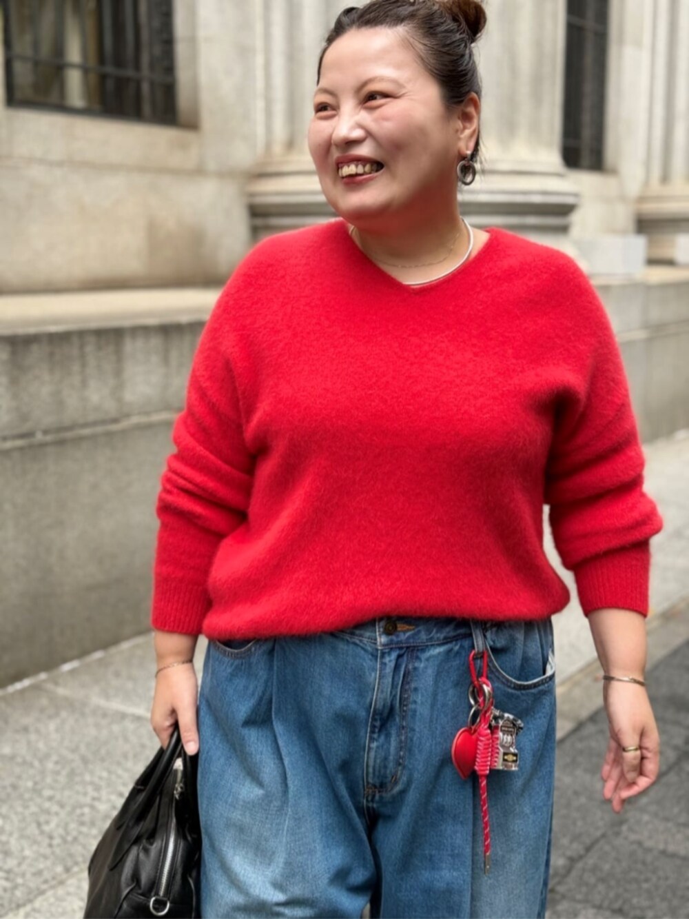 レッド系のニット/セーター、レッド系のチャームを着用したレディースの秋コーディネートの2枚目の写真