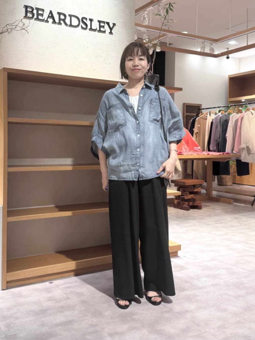 ブラック系のその他パンツ、ブルー系のシャツ/ブラウスを着用したレディースの春コーディネートの2枚目の写真