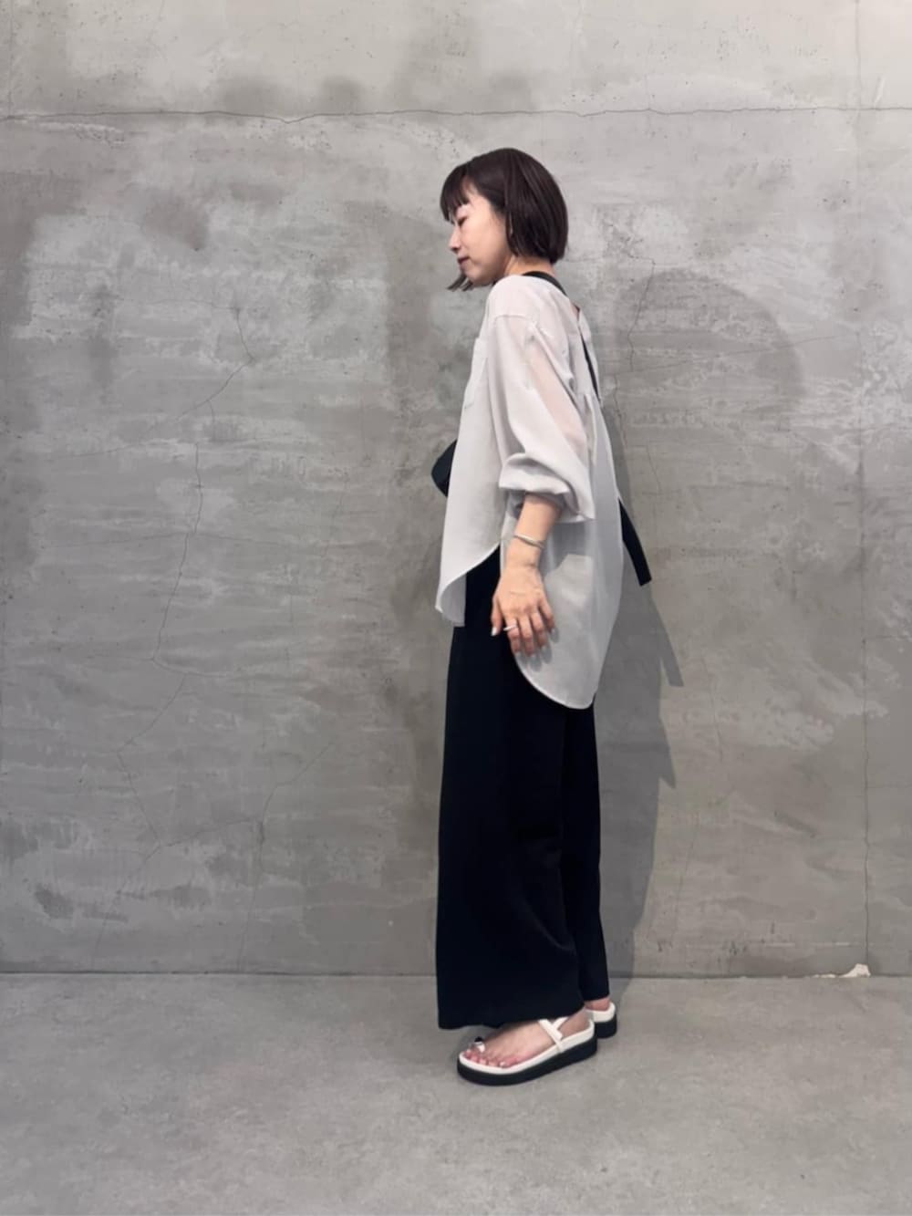 ブラック系のその他パンツ、ブラック系のショルダーバッグ、ホワイト系のサンダルを着用したレディースの冬コーディネートの4枚目の写真