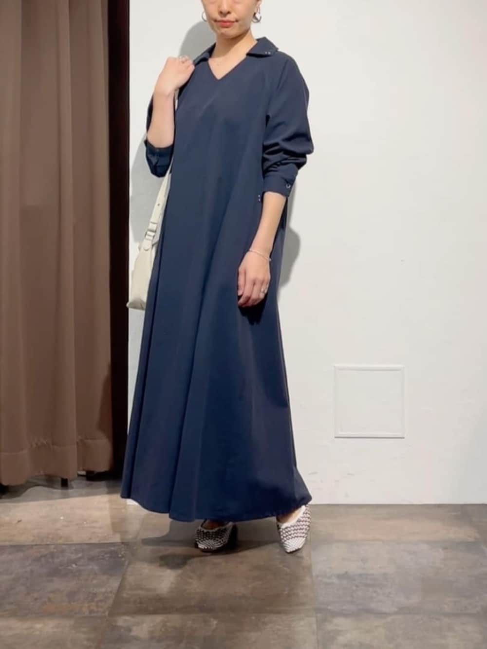 ホワイト系のトートバッグ、ブルー系のワンピースを着用したレディースの春コーディネートの2枚目の写真