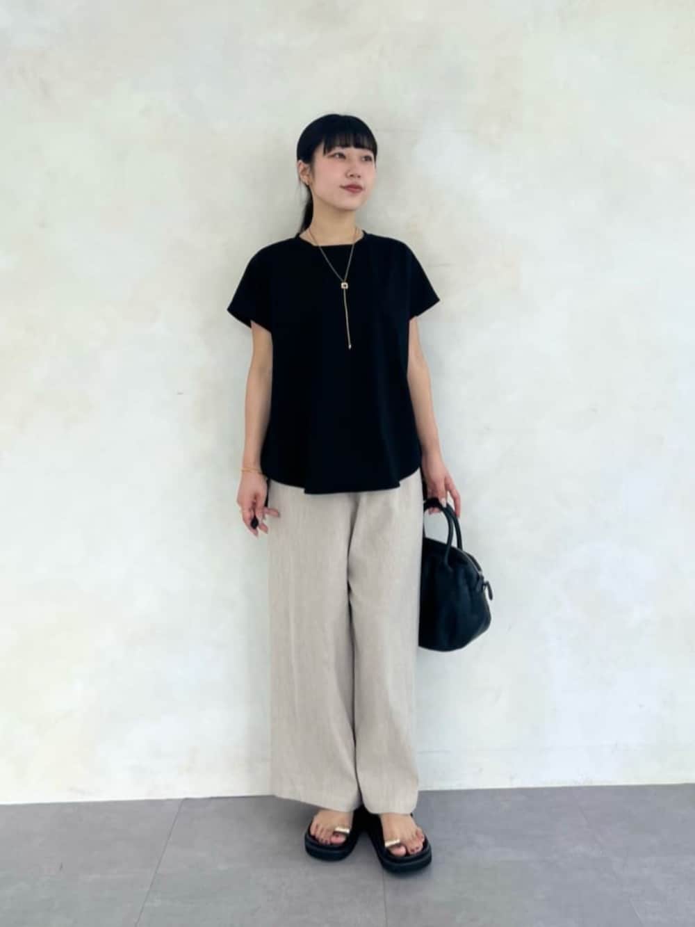 ベージュ系のその他パンツ、ブラック系のTシャツ/カットソー、ブラック系のサンダルを着用したレディースの春コーディネートの2枚目の写真