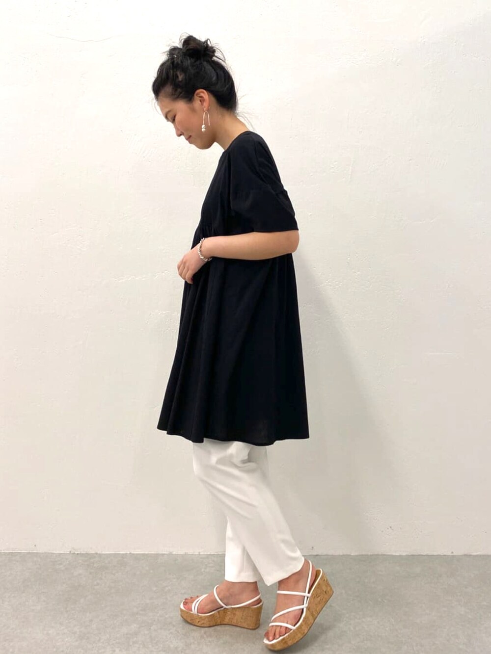 ブラック系のシャツ/ブラウス、ホワイト系のその他パンツ、ホワイト系のその他シューズを着用したレディースの春コーディネートの2枚目の写真