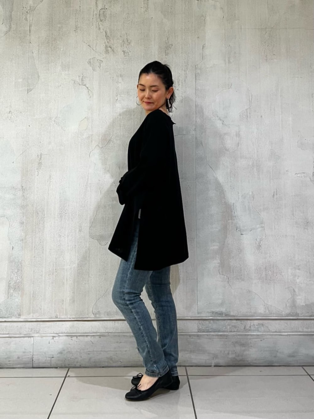 ブルー系のデニムパンツ、ブラック系のハンドバッグ、ブラック系のTシャツ/カットソーを着用したレディースの春コーディネートの3枚目の写真