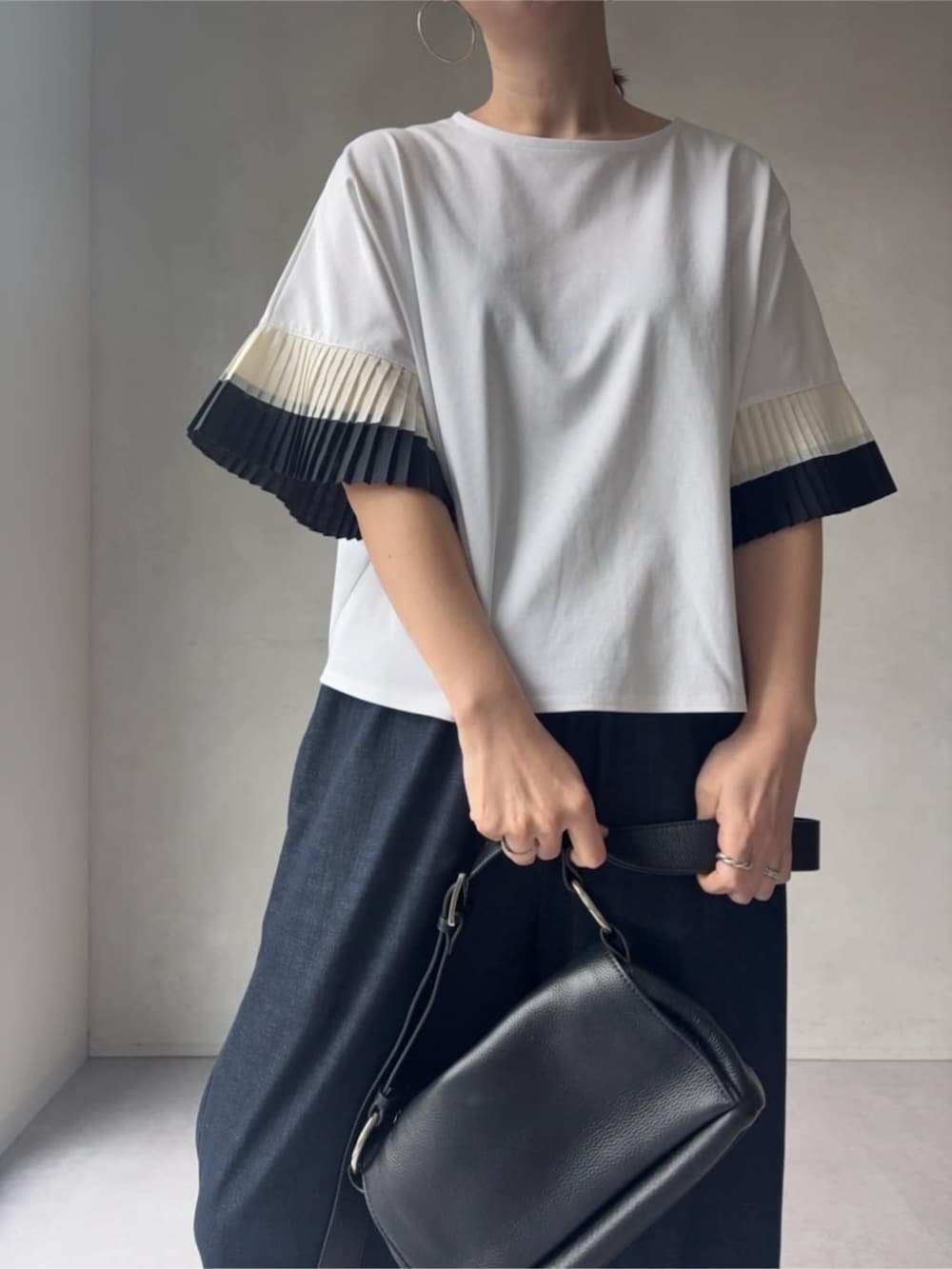 ブルー系のその他パンツ、ブラック系のショルダーバッグ、ホワイト系のサンダルを着用したレディースの春コーディネートの5枚目の写真