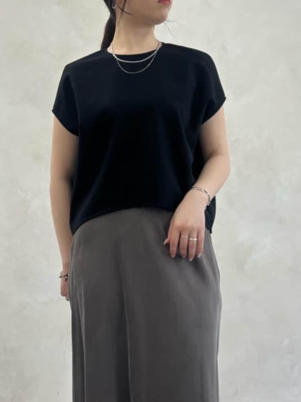 グリーン系のスカート、ブラック系のシャツ/ブラウスを着用したレディースの春コーディネートの5枚目の写真