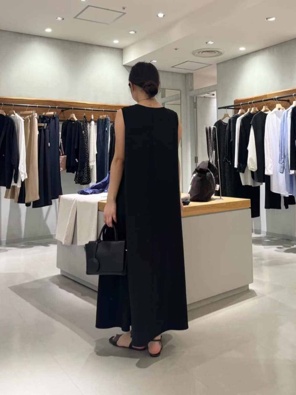 ブラック系のハンドバッグ、ブラック系のワンピースを着用したレディースの春コーディネートの7枚目の写真