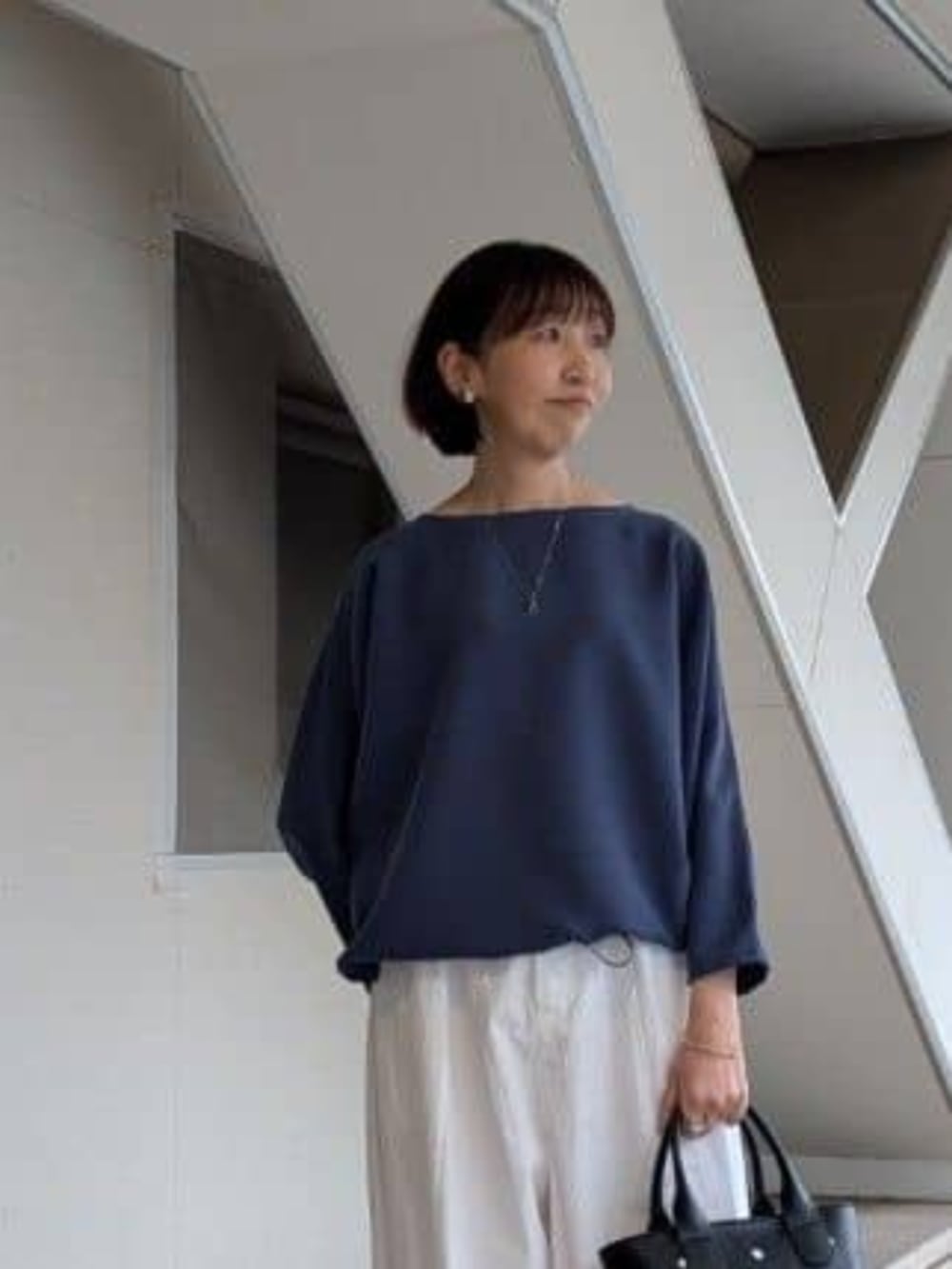 ブラック系のトートバッグ、ブルー系のシャツ/ブラウス、ホワイト系のその他パンツを着用したレディースの冬コーディネートの6枚目の写真